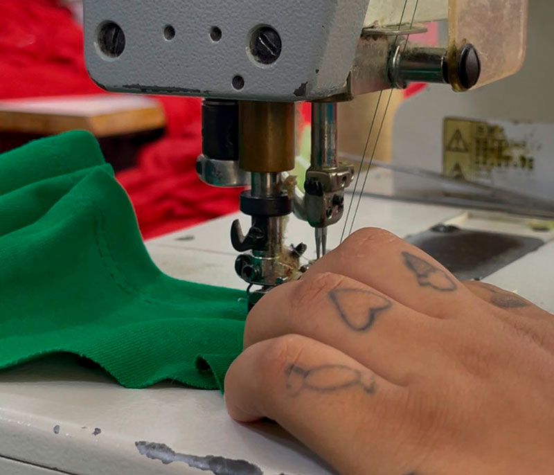 Manos cosiendo en el taller de confección de la Fundación, Centro El Buen Pastor